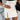 
A high-waist black leather skirt featuring a prominent gold zipper, styled with a white dress shirt. The attire is modeled by a woman, showcasing the fashionable combination of leather and classic white fabric.