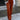 
A person wearing high-waist black slim fit trousers with a contrast stripe, likely brown, standing upright. The trousers are designed to accentuate the waist and fit snugly around the thighs, while the contrast stripe adds a stylish detail.