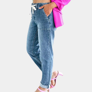 High-waist women's tapered denim jeans featuring a drawstring waist, highlighting a trendy and fashionable design.