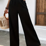 Woman wearing high-waisted pleated pink trousers standing outdoors.