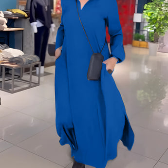 
A blue hooded maxi dress in size 3XL with long sleeves and an elegant casual design, displayed alongside a decorative flowerpot with a houseplant.