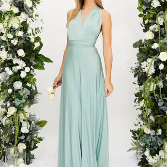 Ivory backless crossover strap bridesmaid maxi dress with pockets, featuring a flowing silhouette. The dress is displayed on a model with long hair, revealing the elegant backless design and crossover straps.