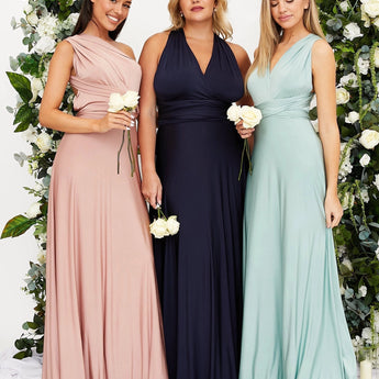Ivory backless maxi dress with crossover straps, featuring pockets, designed for bridesmaids with a flowing gown silhouette.