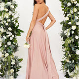 Ivory backless crossover strap bridesmaid maxi dress with pockets, featuring a flowing silhouette and elegant design, perfect for a formal occasion.
