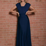 Ivory backless bridesmaid maxi dress featuring crossover straps and pockets, showcasing a flowing design with a focus on the shoulder and neckline area.