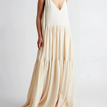 Ivory backless maxi dress with elegant tiered design, featuring thin straps and a flowing silhouette, suitable for evening or formal occasions.