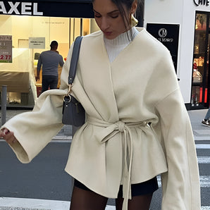 Ivory belted wide sleeve kimono jacket worn by a woman, showcasing its elegant fashion-forward design with flowing sleeves and a cinched waist, suitable for a chic urban fall look.
