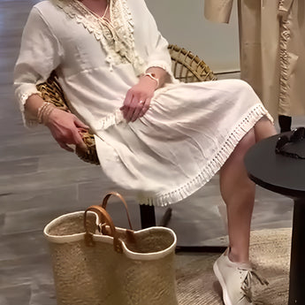 Ivory boho chic lace trim tunic dress with lightweight fabric, featuring short sleeves and a relaxed fit, styled with sandals and a chair in the background.
