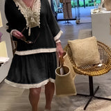 Ivory boho chic lace trim tunic styled as a lightweight summer dress worn by a model with long hair. The tunic features intricate lace detailing, short sleeves, and a relaxed fit, highlighting the waist. The dress is paired with a small bag for a complete chic summer look.