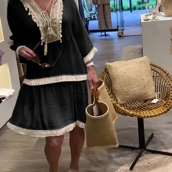 Ivory boho chic lace trim tunic styled as a lightweight summer dress worn by a model with long hair. The tunic features intricate lace detailing, short sleeves, and a relaxed fit, highlighting the waist. The dress is paired with a small bag for a complete chic summer look.