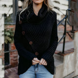 
A woman wearing an oversized ivory chunky knit sweater featuring a buttoned cowl neck, paired with black jeans. The sweater is styled in a loose and fashionable fit, showcasing a cozy and casual look.