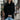
A woman wearing an oversized ivory chunky knit sweater featuring a buttoned cowl neck, paired with black jeans. The sweater is styled in a loose and fashionable fit, showcasing a cozy and casual look.