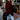 Oversized red chunky knit sweater with a buttoned cowl neck and long sleeves, paired with jeans.