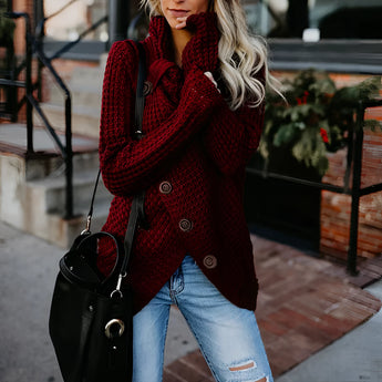 Oversized red chunky knit sweater with a buttoned cowl neck and long sleeves, paired with jeans.