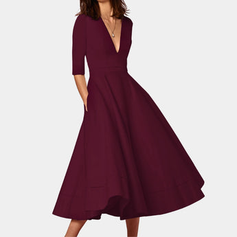 
A red wine-colored, elegant A-line midi dress featuring a formal boat neck and half sleeves, suitable for formal occasions. The dress is worn by a person with styled hair, highlighting the shoulders, neck, and waist.
