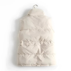 Ivory quilted sleeveless lightweight puffer vest hanging on a clothes hanger, showcasing winter fashion style.