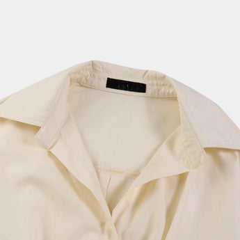 Ivory satin trench coat featuring a sophisticated design with long sleeves, a classic collar, and button detailing. The coat has a subtle beige hue, highlighting its elegant and luxurious appearance, perfect for winter wear.