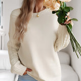 Ivory women's lightweight cable knit sweater featuring a stylish cable pattern, long sleeves, and a comfortable fit, perfect for a fashionable fall look. The sweater is modeled against a neutral background, highlighting its soft texture and elegant neckline.