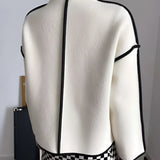 Ivory wool double-breasted jacket with black trim, featuring a high collar and long sleeves.