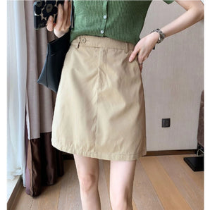 
A women's khaki A-line button-front mini skirt in beige, shown in size XL, styled as part of a casual spring fashion ensemble.
