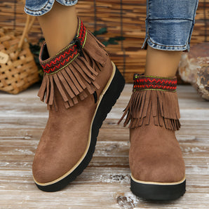 Brown suede fringe ankle boots for women, featuring a bohemian style ideal for fall fashion, shown against a wooden background.