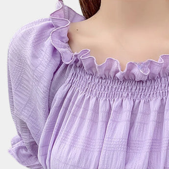 Lavender smocked crop top with puff sleeves and ruffle detailing, showcasing a feminine and stylish design in a light purple fabric.