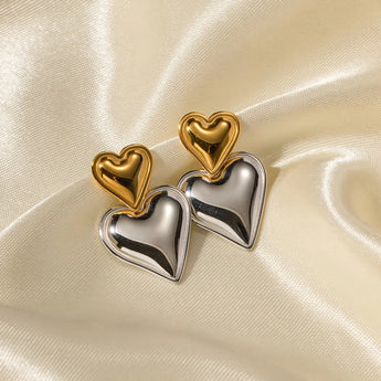 Layered dual-tone heart dangle earrings with silver and gold tones, featuring intricate metal design.