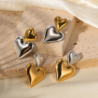 Layered dual-tone heart dangle earrings in silver and gold.