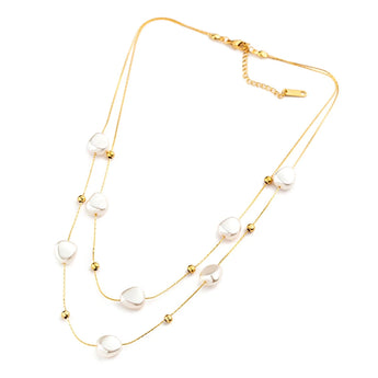 Layered gold plated multi-strand pearl necklace featuring modern designer jewelry elements displayed against a neutral background.