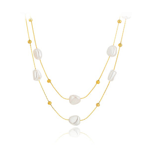 Layered gold plated multi-strand pearl necklace worn by a model, showcasing modern designer jewelry in yellow gold.