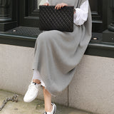 Sleeveless grey midi V-neck sweater dress with a layered design, ideal for urban fashion, showcasing a fitted waist and knee-length hem.