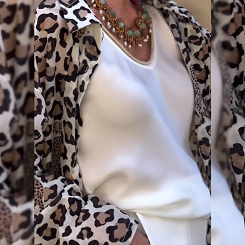 Leopard print cardigan paired with a statement necklace, featuring a chic black and white design, suitable for women over 50.