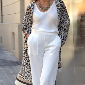 Leopard print cardigan paired with a multicolor bib necklace, modeled by a woman in fashionable attire suitable for women over 50.