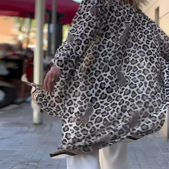 Leopard print cardigan with necklace, showcasing chic fashion for women over 50, highlighting shoulder and sleeve details.