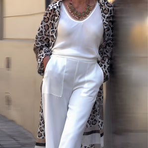 Woman wearing a leopard print cardigan and necklace, styled for a chic fashion look for women over 50. The outfit includes a tailored design with attention to shoulder and sleeve details.