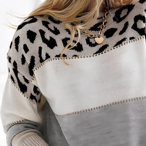 Leopard print color block fringe sweater featuring a mix of grey and white hues, with a stylish neckline, long sleeves, and fringe detailing at the waist, perfect for women's fall fashion.