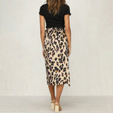Leopard print high-waist midi skirt worn by a woman, showcasing a trendy and fashionable design. The skirt features a bold leopard pattern, extending to knee length, paired with a stylish top and footwear.