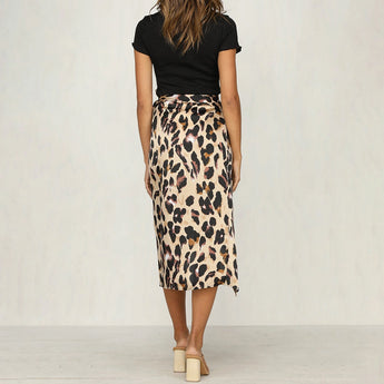 Leopard print high-waist midi skirt worn by a woman, showcasing a trendy and fashionable design. The skirt features a bold leopard pattern, extending to knee length, paired with a stylish top and footwear.