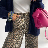 Leopard print jeans with a bold animal print design, showcasing trendy street style, featuring a high waist and sleek fit.