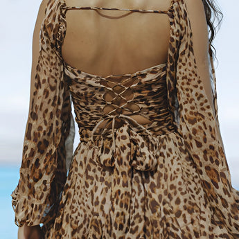 Leopard print open back mini dress featuring elegant pearl accessories, with long sleeves and a fitted waist, designed for a stylish and fashionable look.
