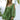 Leopard print open back mini dress in a green color with fashion pearl accessories, featuring a fitted waist, short sleeves, and a thigh-length hem.