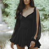 Leopard print open back mini dress with pearl accessories, featuring long sleeves and a fitted waist, worn by a model with dark hair and showing a side profile.