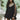 Leopard print open back mini dress with pearl accessories, featuring long sleeves and a fitted waist, worn by a model with dark hair and showing a side profile.