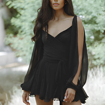 Leopard print open back mini dress with pearl accessories, featuring long sleeves and a fitted waist, worn by a model with dark hair and showing a side profile.