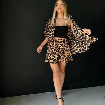 Leopard print women's blazer and skirt set with a trendy design, featuring long sleeves and a stylish waistline, paired with basic pumps.