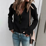 Light beige ribbed knit sweater with a casual chic design, worn by a model pairing it with black trousers, highlighting the sweater's comfortable fit and stylish look.