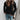 Light beige ribbed knit sweater with a casual chic design, worn by a model pairing it with black trousers, highlighting the sweater's comfortable fit and stylish look.