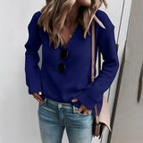A woman wearing a light beige ribbed knit sweater paired with blue jeans. The sweater features a casual chic design with long sleeves and a relaxed fit, highlighting the ribbed texture. The image showcases the shoulder and neckline details of the sweater, set against a neutral background.