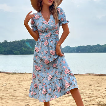 Light blue floral midi dress with a V-neck and short sleeves, worn by a person outdoors with a blue sky and clouds in the background.