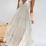 A woman wearing a light blue ruffle sleeve tiered maxi dress, designed for summer fashion, featuring a flowing one-piece garment with distinct ruffled sleeves, suitable for formal occasions. 
